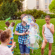 happy kids playing outside with bubbles