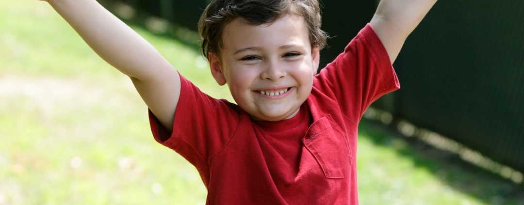 Boy smiling with his hands in the air