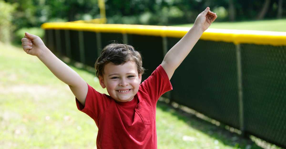 Boy smiling with his hands in the air