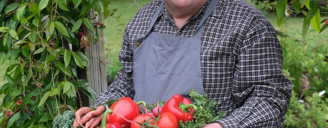 Man with an intellectual disability holding a basket of tomatoes