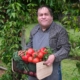 Man with an intellectual disability holding a basket of tomatoes