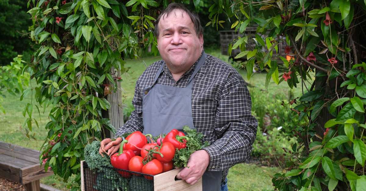 Man with an intellectual disability holding a basket of tomatoes