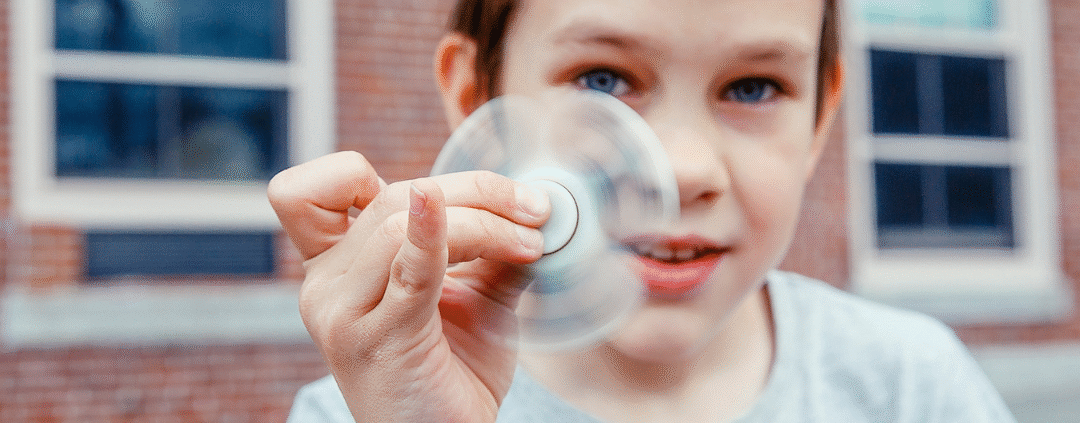 Elementary age boy playing with fidget spinner