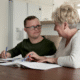 adult with special needs with family member working on paperwork at the kitchen table