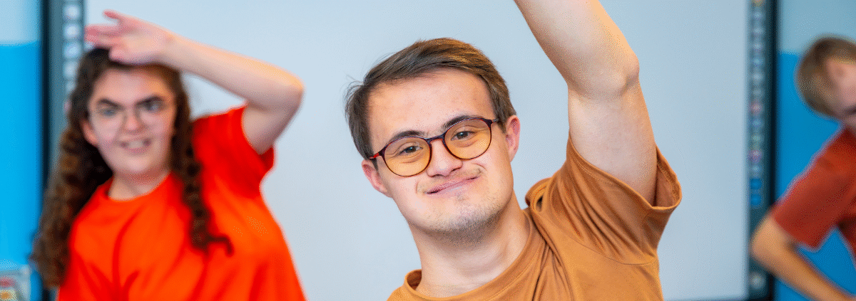 young man with a disability looking at the camera stretching during exercise