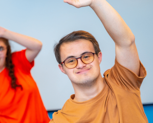 young man with a disability looking at the camera stretching during exercise