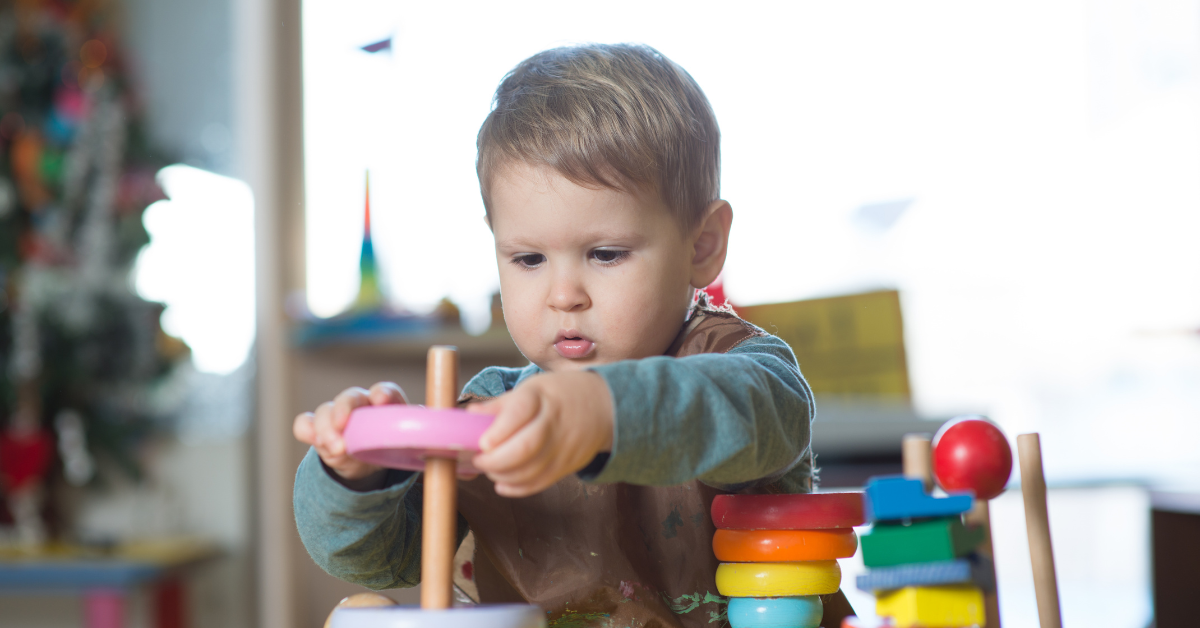 9 toddler boy playing and stacking blocks