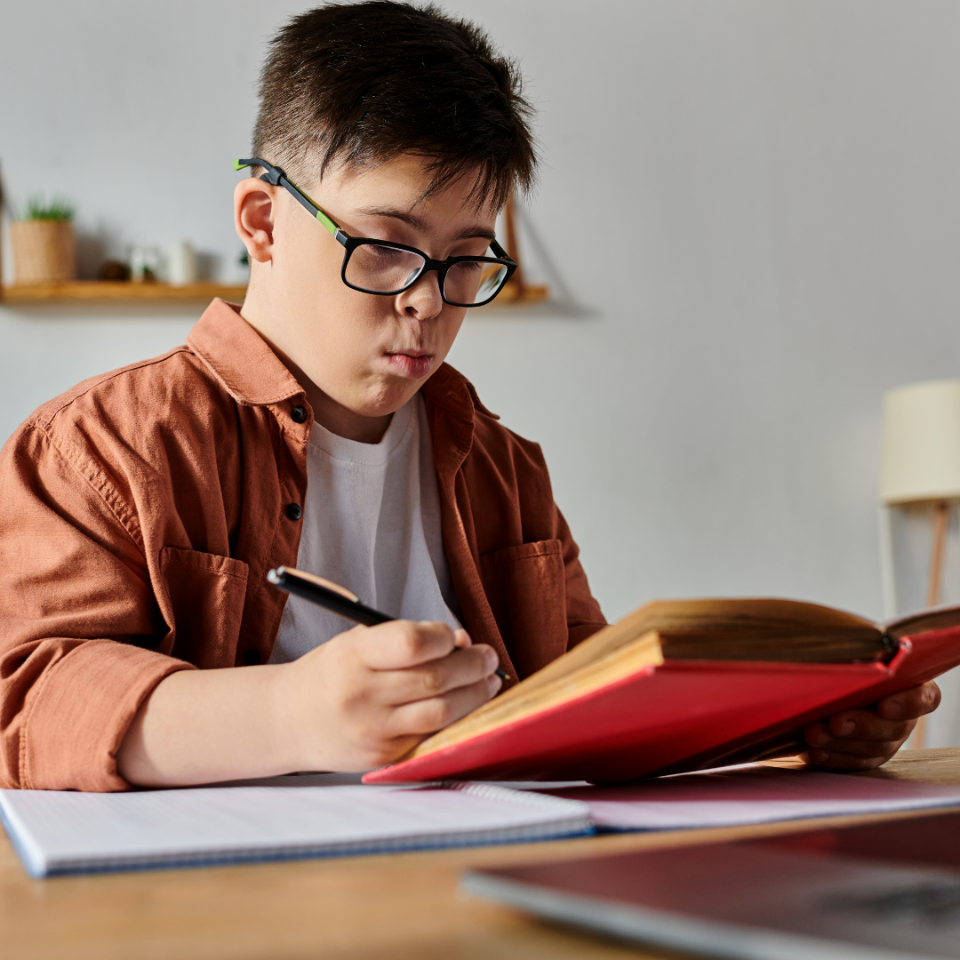 teen boy with glasses holding a pencil and reading a book with an unsure expression on his face