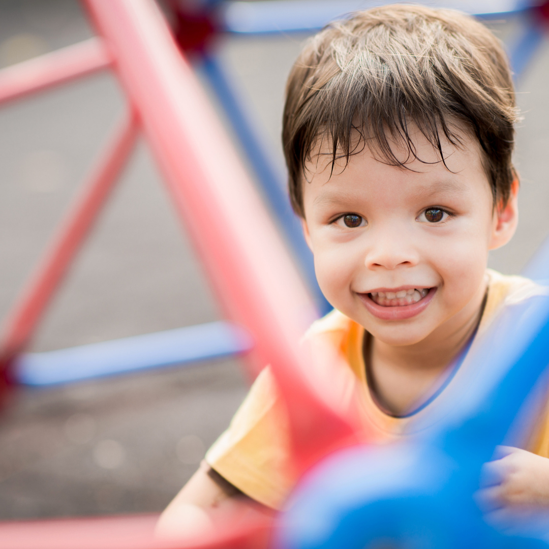 toddler boy smiling on playground