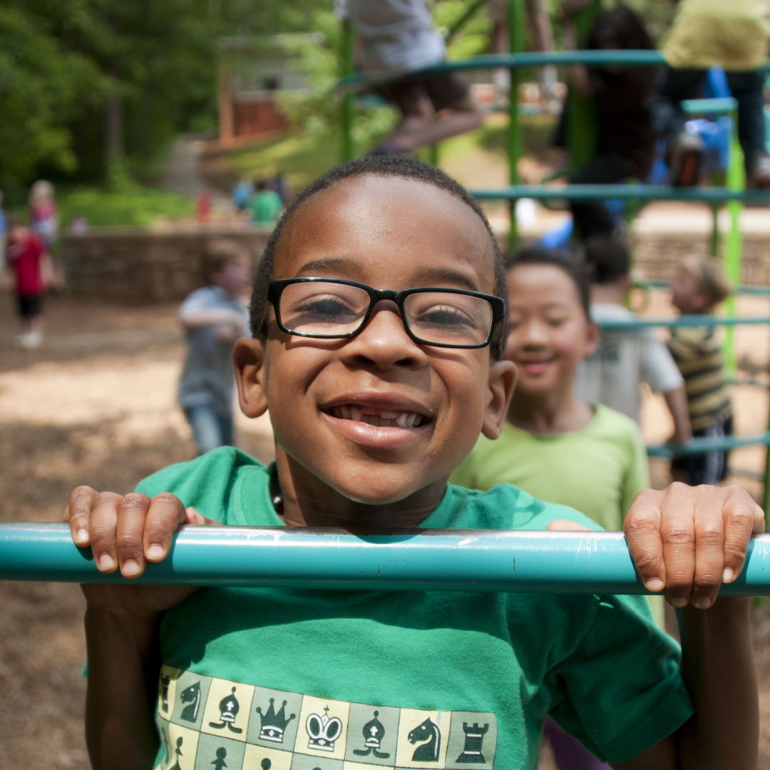 young child in green shirt on playground