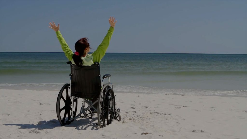 Happy Person on a beach in a wheelchair